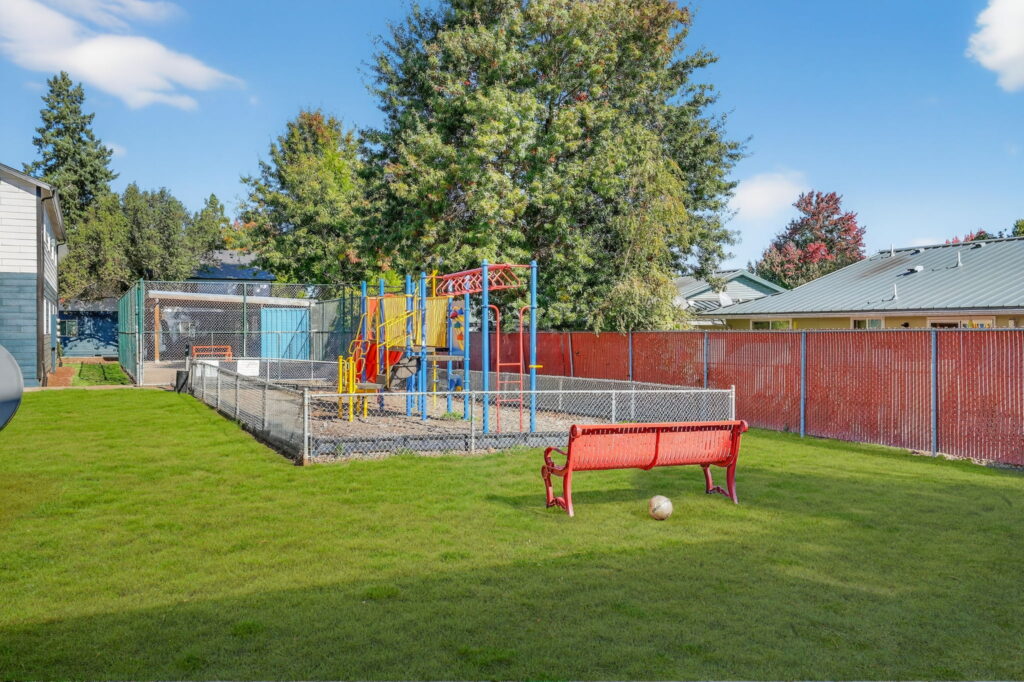 Fenced playground with climbing and slides