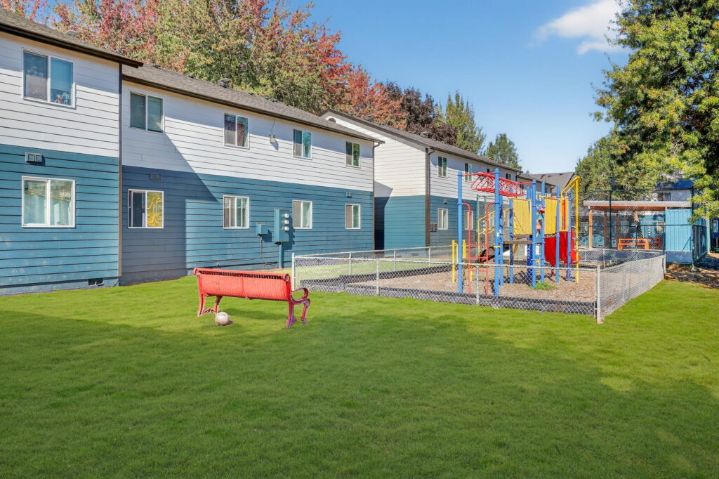 Fenced playground with climbing and slides