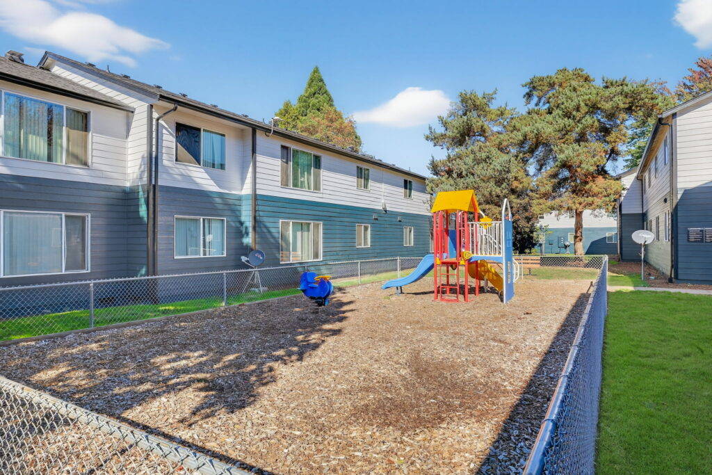Fenced playground with climbing and slides