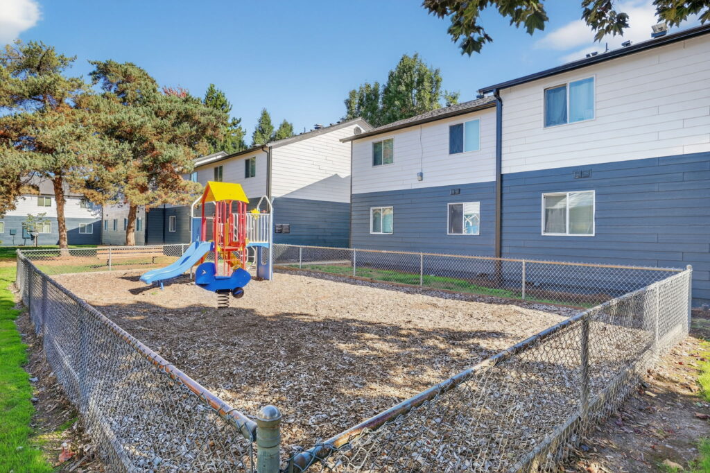Fenced playground with climbing and slides